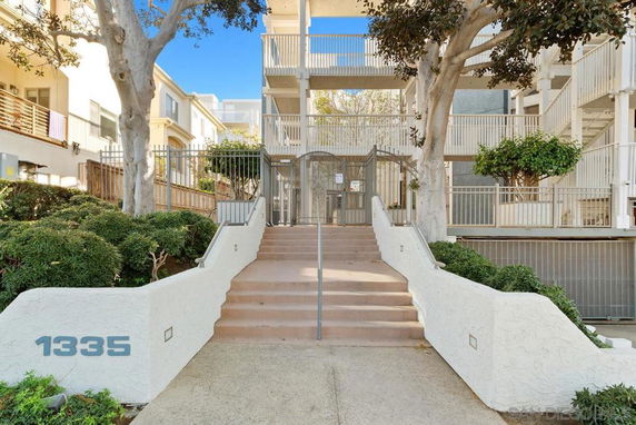 Front view of a multi-story residential building with stairway entrance.
