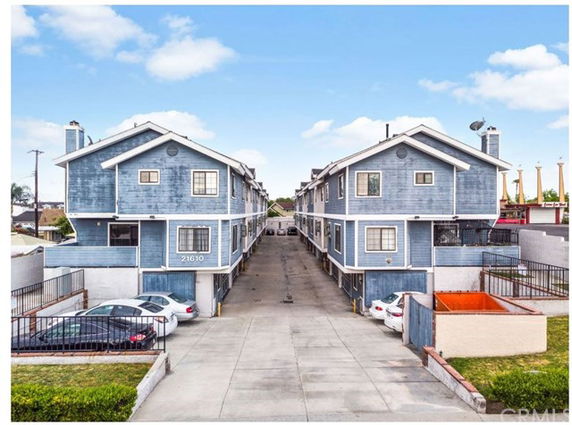 Front view of a residential building with multiple units and a driveway.