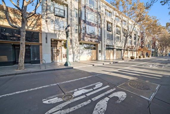 Street view of a modern multi-story building with large windows.