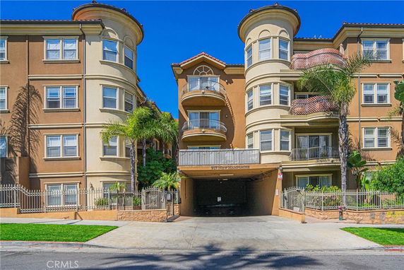 Front view of a multi-story residential building with balconies and rounded structures.