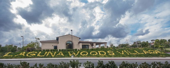 Front view of a single-story building with a sign that reads 'Laguna Woods Village'.