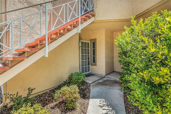 Entrance view of a building with an exterior staircase leading to the upper floor.