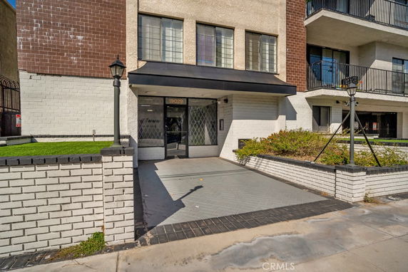 Front view of a multi-story building entrance with a brick exterior.