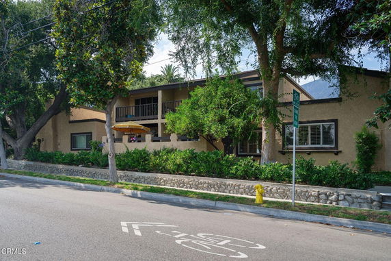 Front view of a house with a multi-story design and a balcony.
