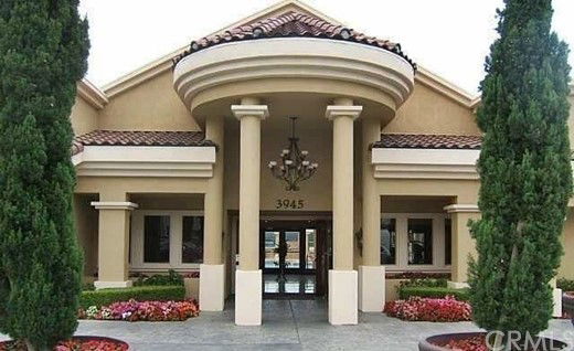 Front view of a large, elegant building with columns and arched entrance.