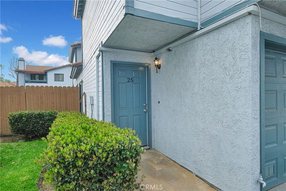 Front view of a residence with a blue door and small porch area.