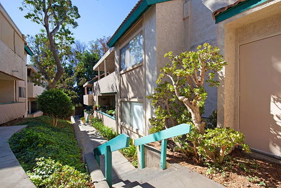 Front view of a multi-story building with exterior stairs and landscaping.