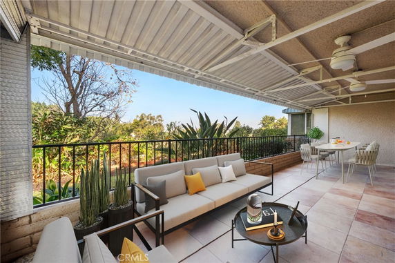 Covered outdoor seating area with a view of surrounding greenery.