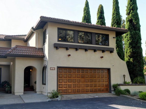 Front view of a two-story house with a double garage and arched entrance.