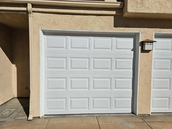 Front view of a garage with a white door in a residential building.