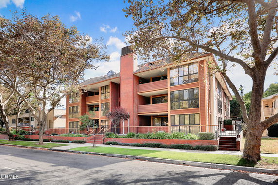 Front view of a multi-story apartment building with large windows and balconies.
