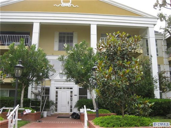 Front view of a multi-story building with a central entrance and balconies.