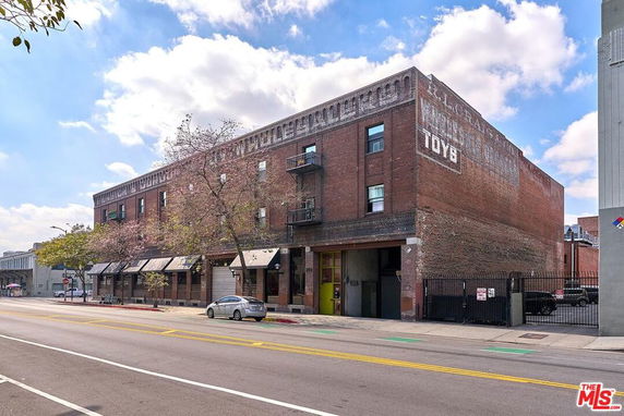 Front view of a multi-story brick building with vintage signage.
