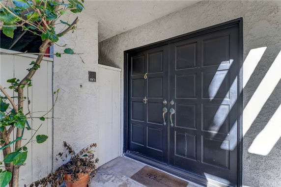 Front view of a house entrance with double black doors.
