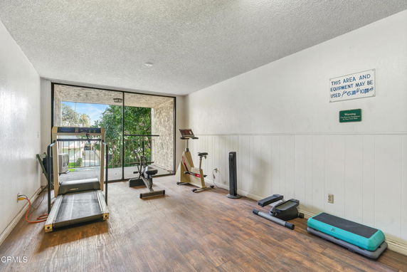 Room with exercise equipment including treadmill and stationary bicycle.