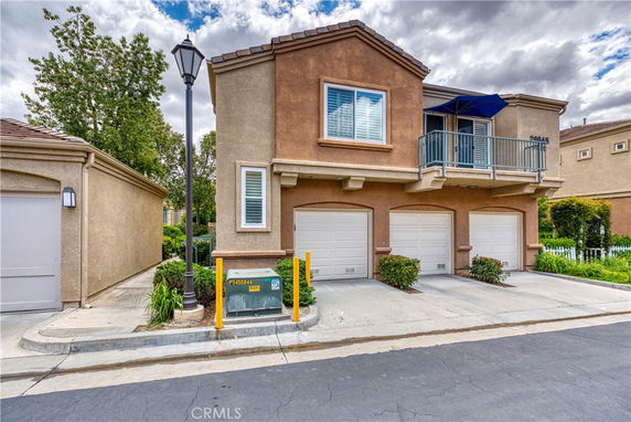 Front view of a house with a three-car garage and a balcony.