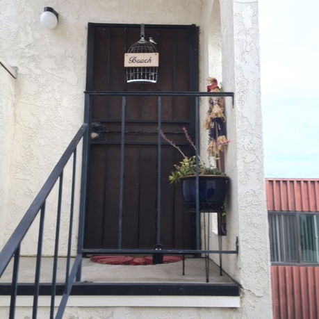 Front view of a door entrance with a small porch and railing.