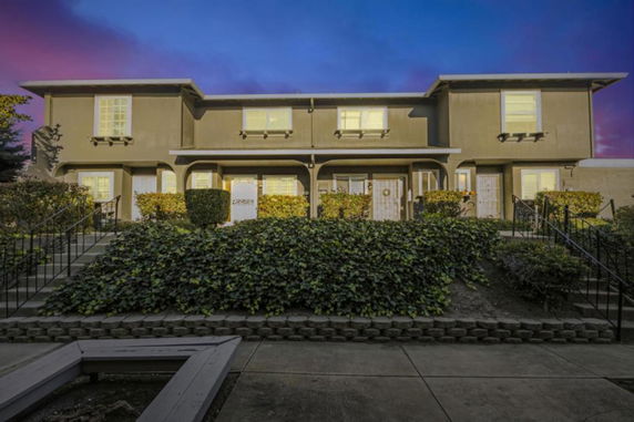 Front view of a two-story residential building with multiple entrances.