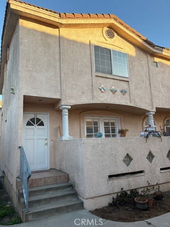 Front view of a two-story house with a small porch and decorative facade.
