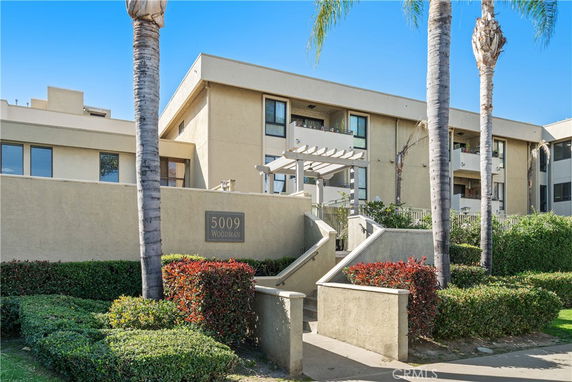 Front view of a multi-story building with balconies and a well-maintained entrance.