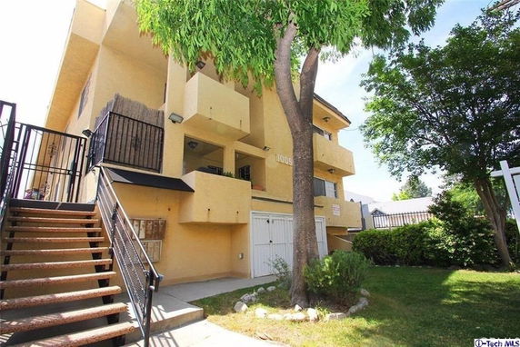 Side view of a multi-story residential building with external staircases and balconies.