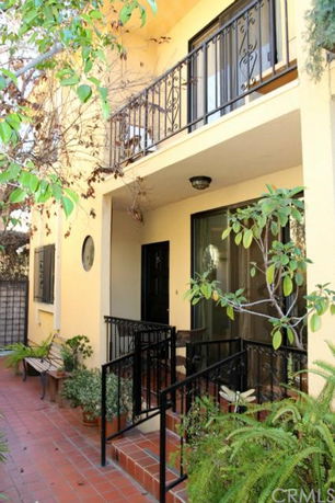 Front view of a two-story house with a balcony and terracotta tiles.
