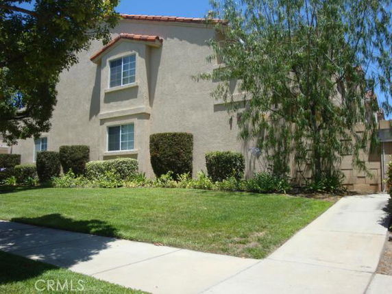 Front view of a two-story house with beige exterior and red roof tiles.