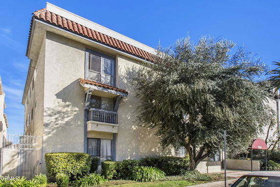 Front view of a multi-story building with a tiled roof and balconies.