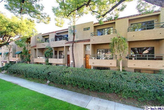 Front view of a multi-story apartment building with balconies.