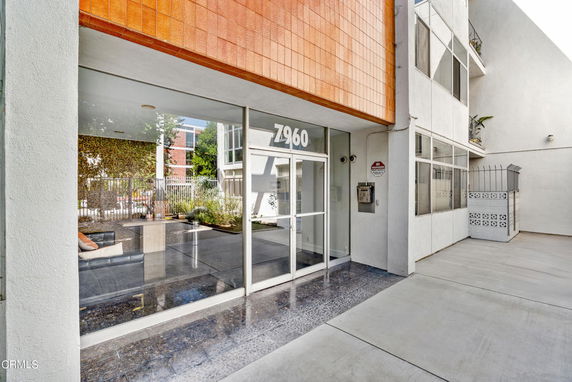 Front view of a building entrance with a glass door and address number displayed above.