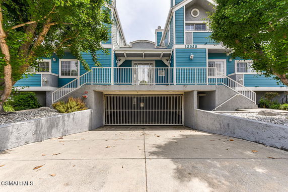 Front view of a two-story building with gated parking entrance.