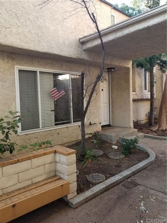 Front view of a house with an entryway and garden area.
