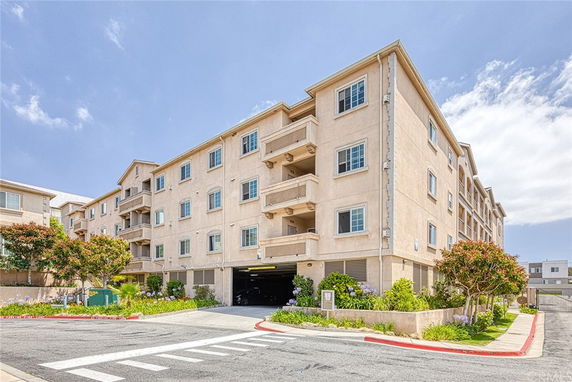 Front view of a multi-story apartment building with balconies.