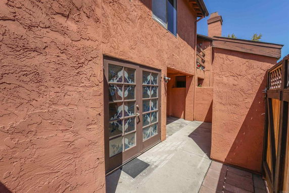 Front view of a stucco-finished house with glass panel door entrance.