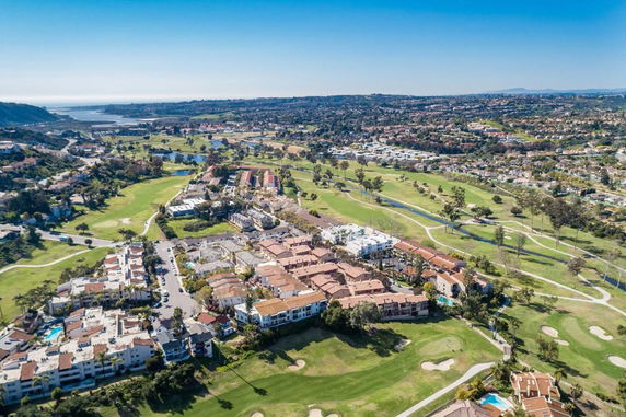 Aerial view of a residential area surrounded by green fields and landscape.