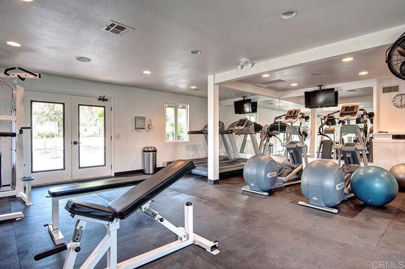 Indoor gym area with exercise equipment and mirrors.