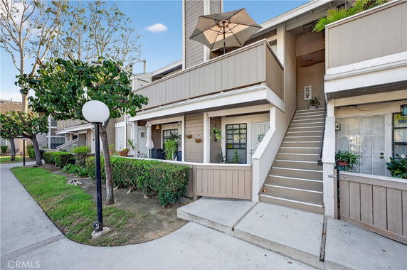 Front view of a two-story residential building with stairs leading to the upper level.