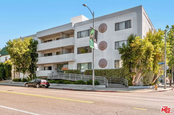 Front view of a modern three-story apartment building with balconies.