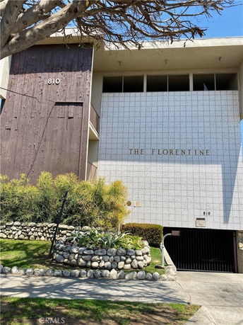 Front view of a building with a textured facade and garage entrance.