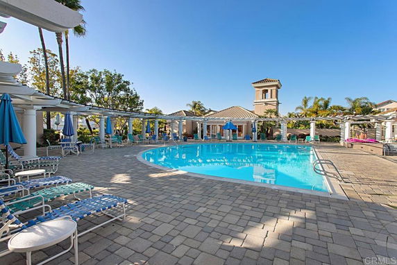 Outdoor swimming pool area with lounge chairs and umbrellas.