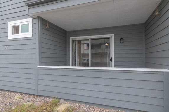 Front view of a house with gray siding and a small porch area.
