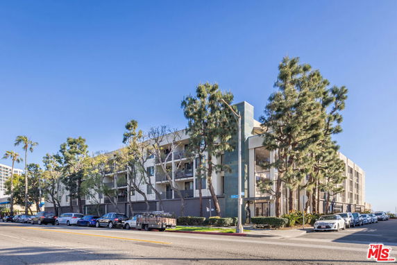 Front view of a multi-story residential building on a street corner.