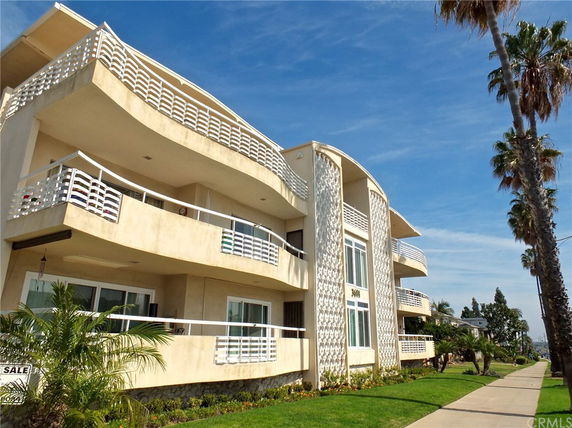 Front view of a multi-story building with curved balconies and decorative patterns on the exterior.