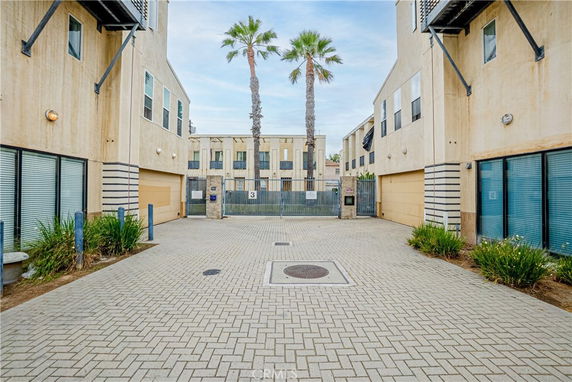 Front view of a modern multi-story apartment complex with large windows and beige walls.