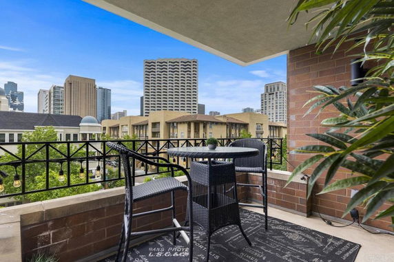 Balcony view of city buildings with outdoor seating.