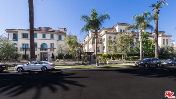 Front view of a multi-story building with Mediterranean architectural style.