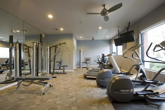 Interior view of a gym with various exercise equipment and mirrors.