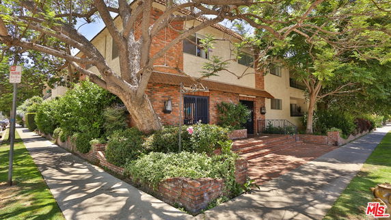 Front view of a two-story house with brick and stucco exterior.