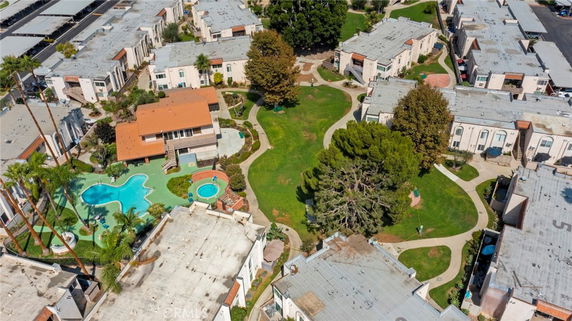 Aerial view of a residential complex with multiple buildings, swimming pools, and landscaped gardens.