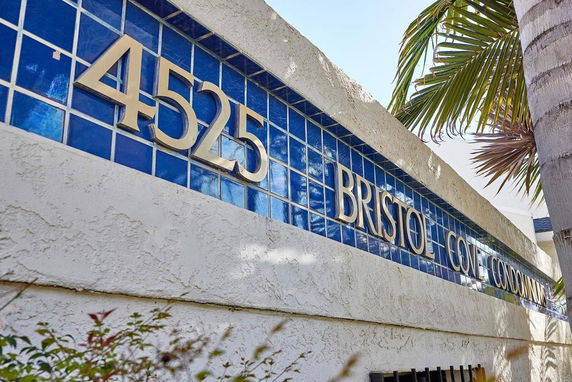 Front view of a condominium building with an address sign in large numbers and letters.